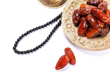 Beyaz bir arka plan üzerinde geleneksel bir tepsi üzerinde kurutulmuş tarihleri. Ramazan Kareem