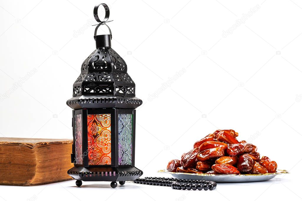 The Muslim feast of the holy month of Ramadan Kareem. Beautiful background with a shining lantern Fanus and dried dates on white. Free space for your text
