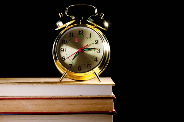 Alarm clock standing on books — Stock Photo, Image