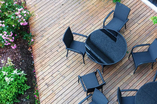 Schwarze Stühle und ein Tisch im Regen — Stockfoto