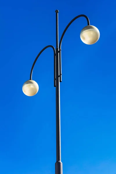 Straatverlichting op hoge pijlers en de blauwe hemel — Stockfoto