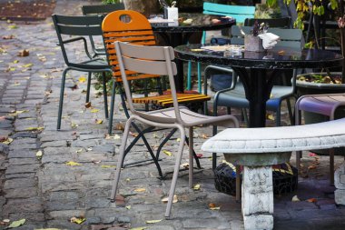 Masalar ve sandalyeler bir kafede, açık havada.