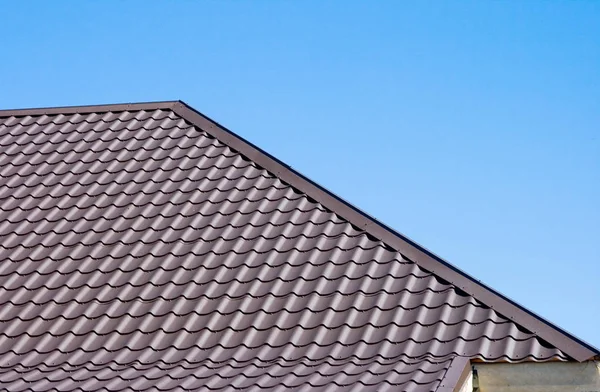 Brown roof of metal roofing on the sky background Stock Picture