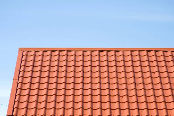 Red roof of metal roofing on the sky background Royalty Free Stock Photos