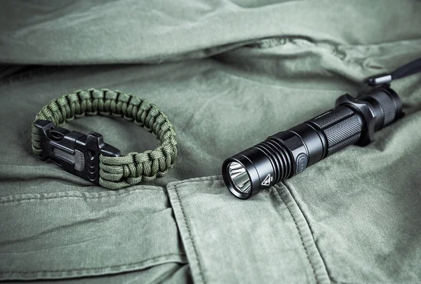Military paracord bracelet and tactical torch — Stock Photo, Image