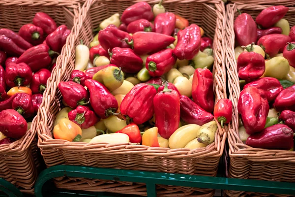 Mazzo di peperoni alla paprica rossi e gialli in scatole di vimini nel supermercato — Foto Stock