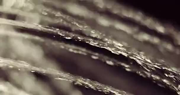 Chorro de agua funcionando macro disparo. Filmación del chorro de agua sobre fondo negro — Vídeos de Stock