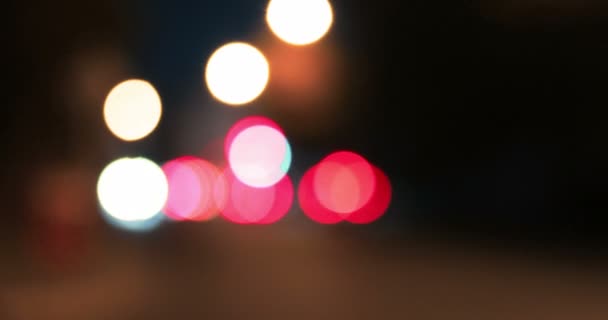 Bokeh shot of moving blurred lights in night city — Stock Video