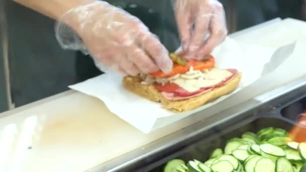 Un chef preparando un sándwich con ensalada fresca — Vídeos de Stock