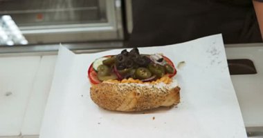 İşçinin elleri sandviçi hazırlar.