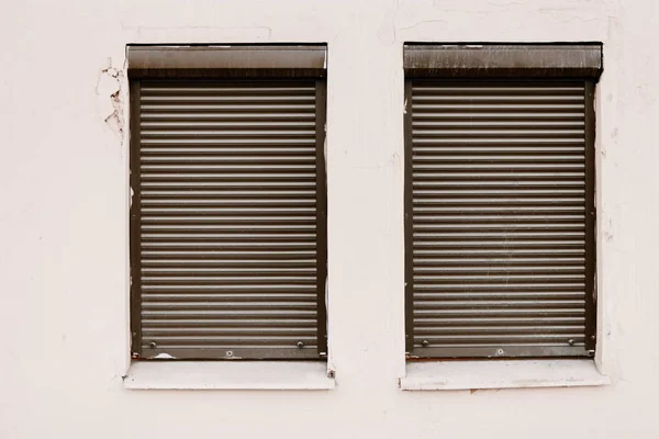 Muur met twee gesloten door rolluik windows — Stockfoto