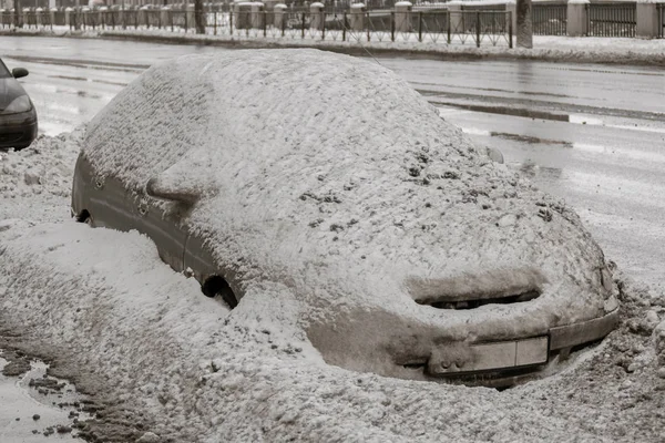 Машина на зимовій дорозі вкрита снігом. Транспортний засіб на засніженій алеї вранці після снігопадів у місті . — стокове фото