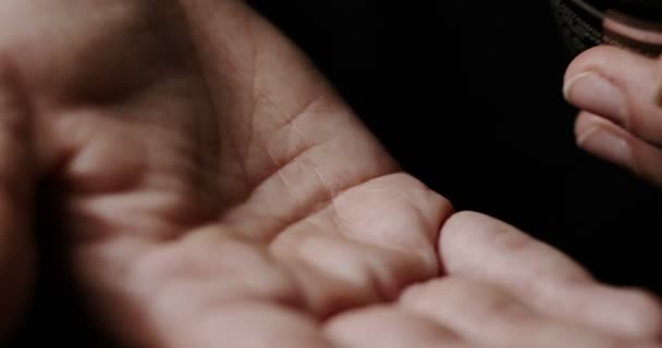 Femme renverser de grandes pilules à base de plantes de bouteille en plastique sur sa paume .