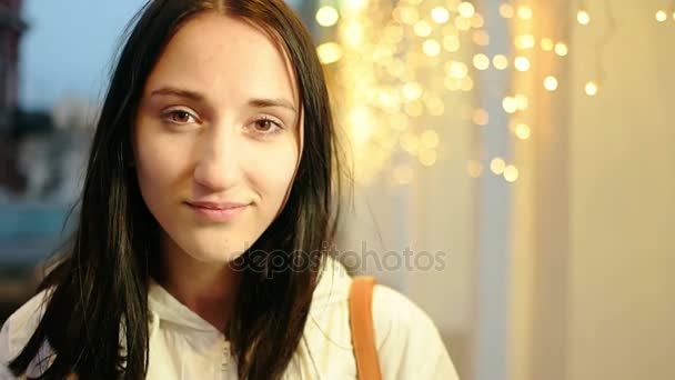 Молодая привлекательная девушка возле мигающих праздничных украшений, желтый винтажный тон — стоковое видео