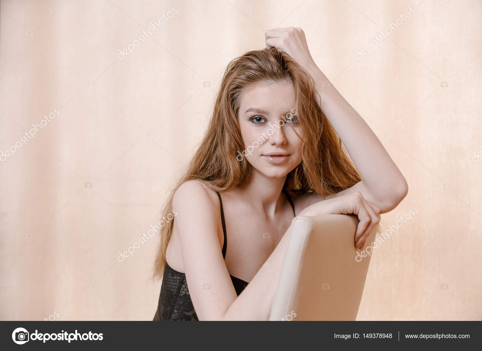 Blond Haired Woman In Pensive State Posing On Chair With Copyspace