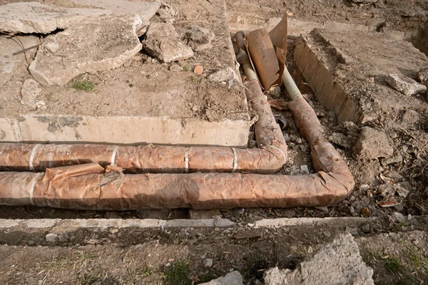 Tubulação de aço enferrujada com isolação térmica no canteiro de obras. Reparação do sistema central de água quente — Fotografia de Stock