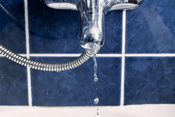 Vista frontal del grifo de agua en el baño con flujo de agua congelada en el aire — Foto de Stock