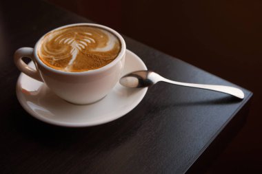 Tablo köşede duruyor kaşık ile sourcer tarihinde kapuçino fincan