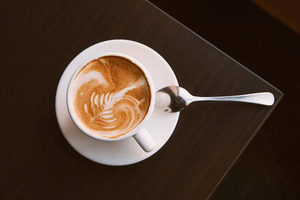 Cappuccino šálek na pohled shora tmavé dřevo stůl rohu, copyspace — Stock fotografie