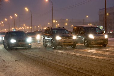St.Petersburg, Rusya 24.02.2017: Arabalar gece zaman kar yolu üzerinde