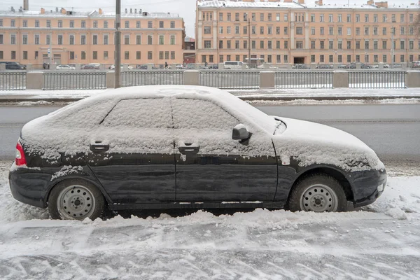 Vista lateral del coche aparcado cubierto de nieve después de las nevadas en el terraplén del canal de Obvodnoy en San Petersburgo Rusia — Foto de Stock