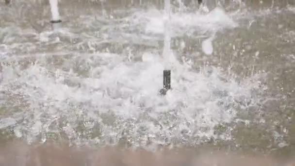 Wassertropfen und -spritzer fliegen in Zeitlupe durch die Luft und spritzen über die Oberfläche. Stadtpark-Brunnen funktioniert — Stockvideo