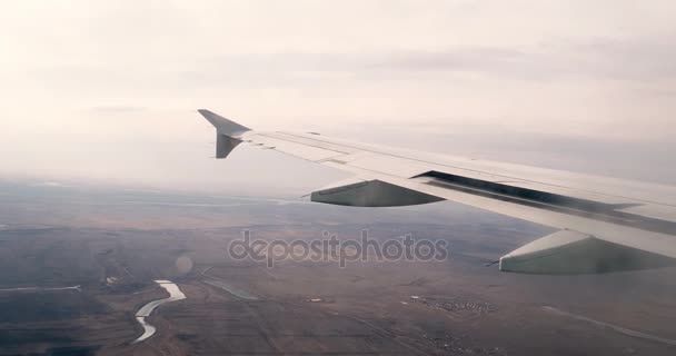 Крыло самолета, летящего рядом с землей. Вид из окна самолета. Винтажная классификация. Часть крыла из окна самолета . — стоковое видео
