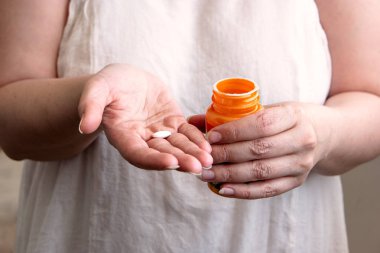 Bir tablet bir palmiye ve başka bir turuncu hap şişesi üzerinde