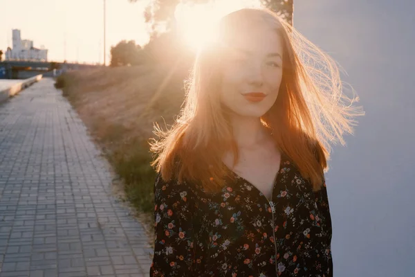 Szczęśliwa dziewczyna pozuje w mieście podświetlany przez zachód słońca — Zdjęcie stockowe