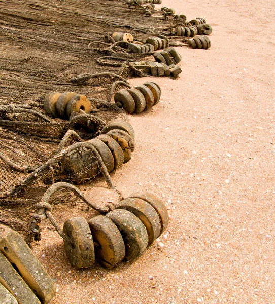 Oude visnet met bobbers praalwagens op het gouden zand en veel van copyspace — Stockfoto