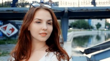 Genç kadın Merhaba de vlog gibi sosyal medya için. Güneşli havada mutlu gülümseyen genç redhead