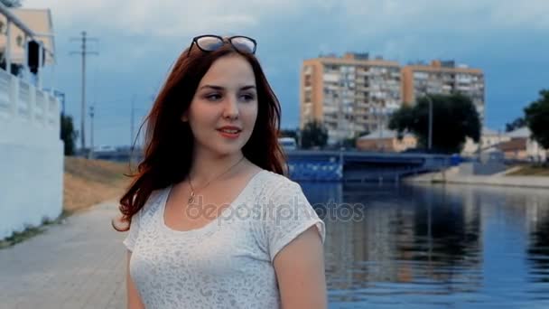 Porträt einer hübschen Frau mit roten Haaren, die am Ufer des Flusses posiert und weißes Hemd trägt — Stockvideo