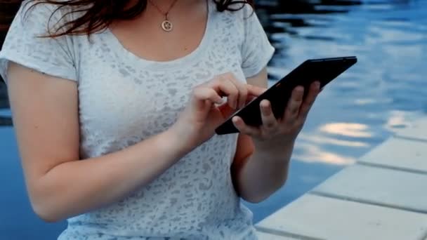 Mujer joven usando tableta en el primer plano de la calle — Vídeo de stock