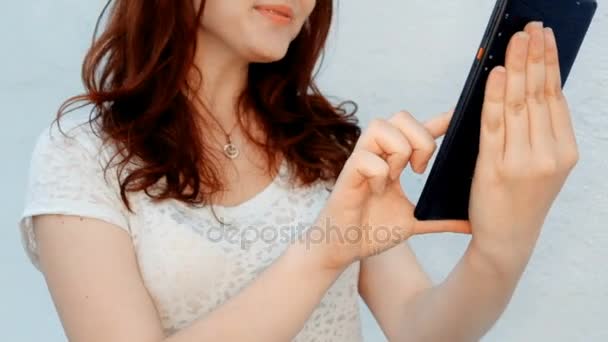 Cute young women having fun while browsing a tablet outside — Stock Video