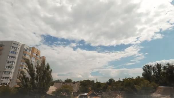 Krásný den Timelapse. mraky létat nad stromy a budovy — Stock video