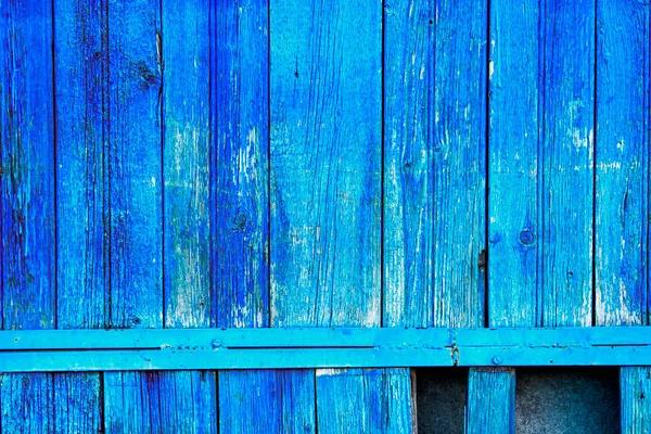 Old fence planks painted in bright blue color
