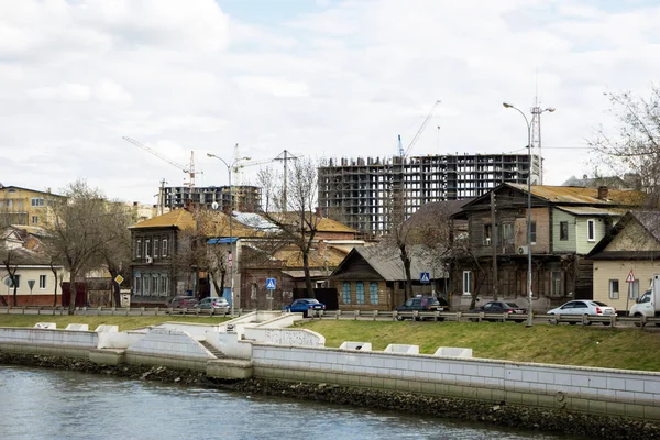 Astrakhan, Rusia, 21 martie 2018: Multe clădiri vechi din lemn în fața sitului modern de dezvoltare — Fotografie, imagine de stoc