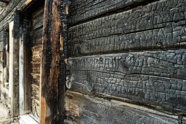 Yanmış siyah ahşap duvar. Gecekondu ev yandı kurullarında görüntüsünü açı
