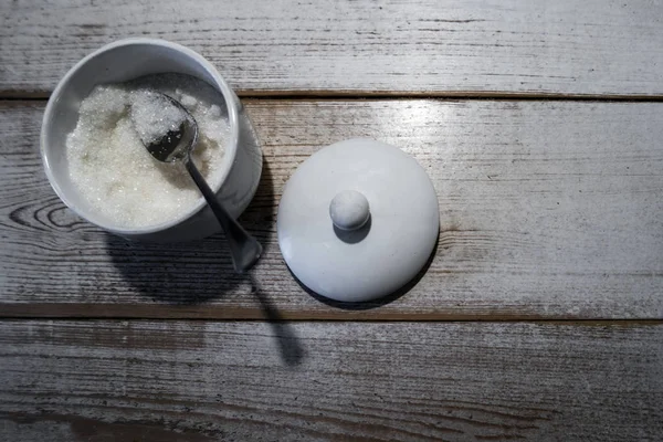 Gula dengan sendok dalam mangkuk. Pada kayu putih yang lapuk . — Stok Foto