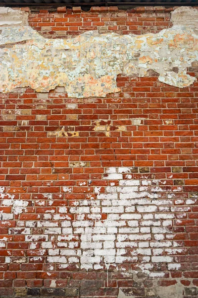 Pared de ladrillo envejecido con manchas de pintura blanca y yeso vertical — Foto de Stock