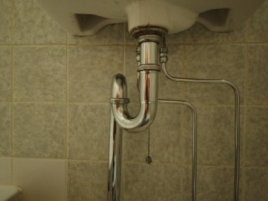 Havza hortumu ya da lavabo lavabosu aşağıdan görünüyor. Kapakçıklı krom metal borular takıldı.
