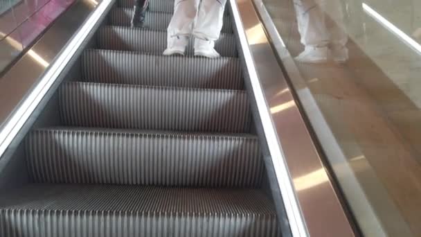 Nahaufnahme einer jungen Frau und eines Mannes, die auf der Rolltreppe in einem Einkaufszentrum stehen — Stockvideo