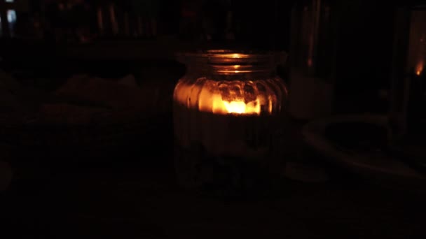 Свеча в стекле горит на столике кафе — стоковое видео