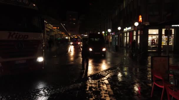 Bonn Germany, 23 listopada 2019: Widok na przystanek autobusowy w deszczową noc z autobusami i pieszymi 4k 50fps clip — Wideo stockowe