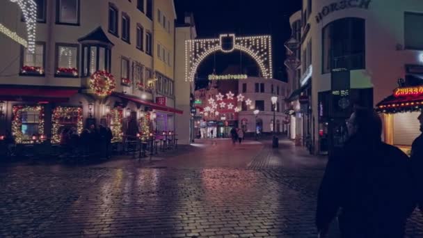 Bonn - 14. Dezember 2019: Weihnachtsmarkt in der Nacht. Menschen laufen die geschmückte Straße zu Weihnachten entlang — Stockvideo