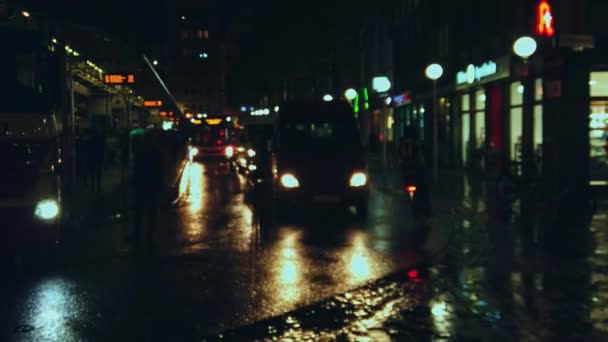Przystanek autobusowy zalany prysznicami w nocy, wiele samochodów, pieszych, rowerzystów poruszają się — Wideo stockowe