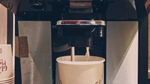 Koffiezetapparaat in de openbare ruimte schenkt koffie en melk tegelijk in een glas — Stockvideo