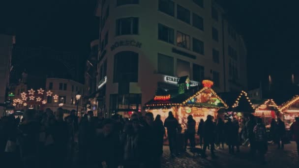 Bonn Alemania, 23 dic. 2019: Multitud de personas diversas de Alemania caminan por los puestos iluminados del mercado navideño 4k slomo — Vídeo de stock