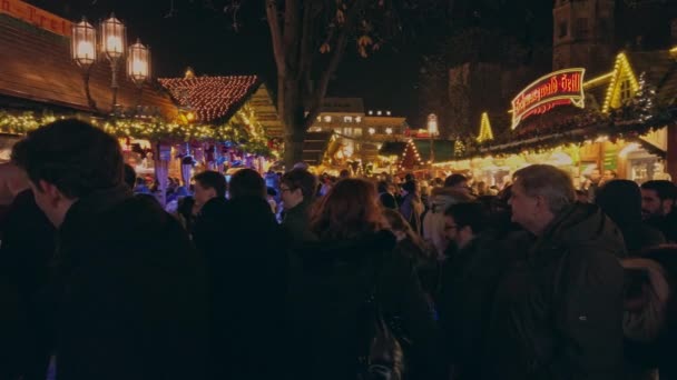 Bonn Alemania, 23 dic 2019: Los puestos de mercado navideños están decorados con guirnaldas ardientes y la gente feliz camina para recibir regalos — Vídeo de stock