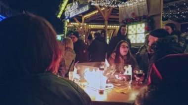 Bonn Almanya, 23 Aralık 2019: Bir grup insan, bir fast food büfesinin yanındaki sokakta gaz alevlerinin tadını çıkarıyor